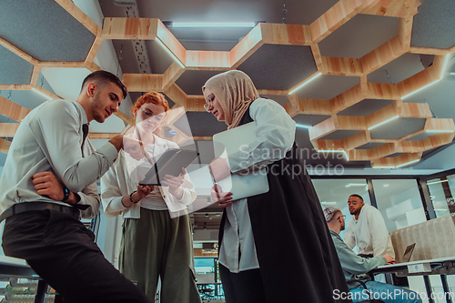 Image of Young group of business people brainstorming together in a startup space, discussing business projects, investments, and solving challenges.