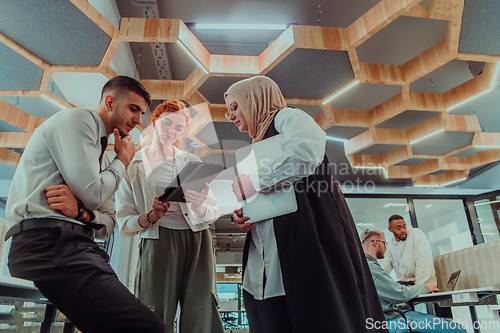 Image of Young group of business people brainstorming together in a startup space, discussing business projects, investments, and solving challenges.