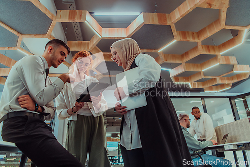 Image of Young group of business people brainstorming together in a startup space, discussing business projects, investments, and solving challenges.