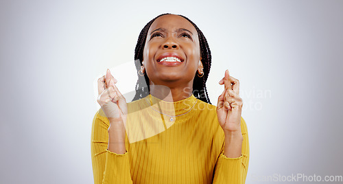 Image of Fingers crossed, praying and black woman in studio with sign of good luck for bonus, prize or lottery in white background. Hope, wish and nervous person with hands, emoji and waiting for results