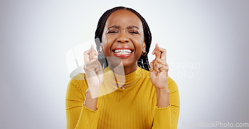 Image of Fingers crossed, praying and black woman in studio with sign of good luck for bonus, prize or lottery in white background. Hope, wish and nervous person with hands, emoji and waiting for results