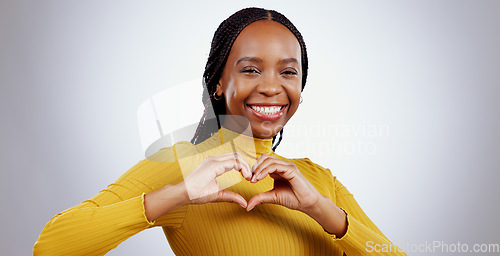 Image of Heart, hands and portrait of woman in studio for kindness, icon and charity donation on white background. Happy african model show sign of love, emoji and thank you for hope, support or care of peace