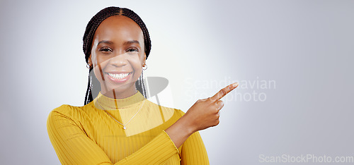 Image of Portrait, smile and black woman with hand pointing in studio for presentation, checklist or promo on grey background. Timeline, schedule and face of female model show faq, menu or step, guide or info