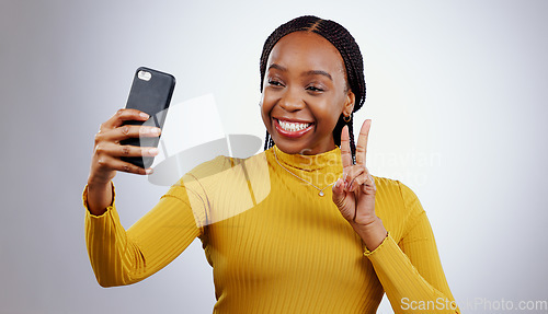 Image of Studio, peace sign or black woman taking selfie on social media with confidence, post or smile. African lady, memory or happy influencer taking a photograph, vlog or picture online on grey background