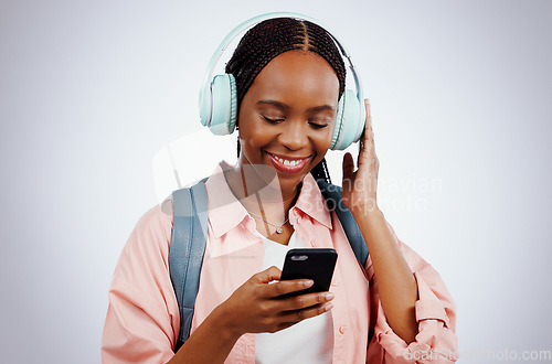 Image of Woman, student and headphones on mobile for music, elearning audio and education on a white background. Happy african person in backpack and electronics for listening or streaming on phone in studio