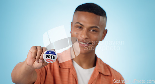 Image of Man, vote sticker and smile for election, positive and politics for america, government and blue studio background. Badge, voter choice and support for party, registration or hand for voting register