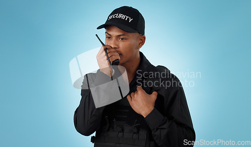 Image of Security guard, walkie talkie and man with communication in a studio with police and law enforcement. Blue background, surveillance and officer with discussion and talking for safety and danger