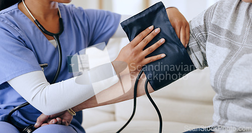 Image of Caregiver hands, home and blood pressure test for healthcare service, support and nurse for medical monitor. Doctor with patient arm and helping with diabetes or hypertension exam on sofa and machine