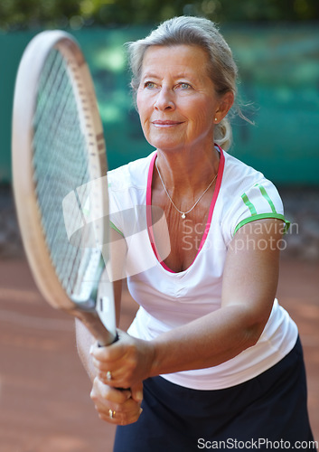 Image of Woman, tennis racket and ready serve on court for outdoor sport, competition or game match. Senior, female person and ball practice as retirement hobby or mobility training, exercise or summer fun