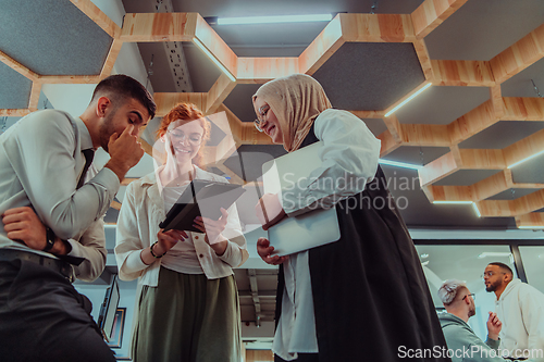 Image of Young group of business people brainstorming together in a startup space, discussing business projects, investments, and solving challenges.