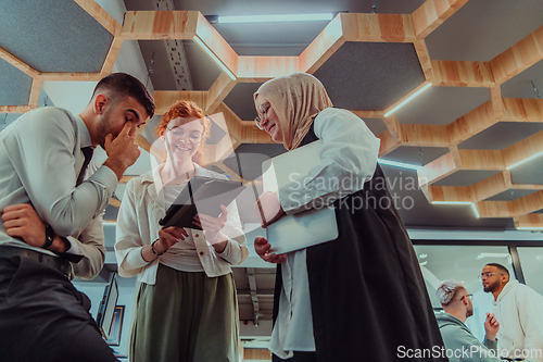 Image of Young group of business people brainstorming together in a startup space, discussing business projects, investments, and solving challenges.