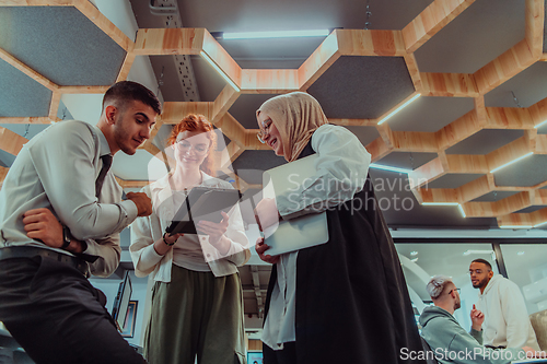 Image of Young group of business people brainstorming together in a startup space, discussing business projects, investments, and solving challenges.