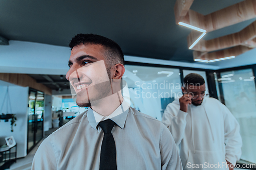 Image of A group of young business professionals stands together, taking a well-deserved break from their busy workday, showcasing camaraderie, teamwork, and a moment of relaxation in their dynamic workplace