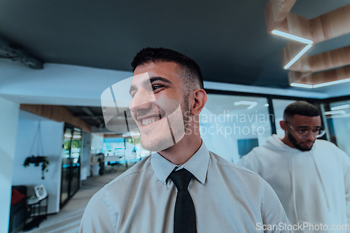 Image of A group of young business professionals stands together, taking a well-deserved break from their busy workday, showcasing camaraderie, teamwork, and a moment of relaxation in their dynamic workplace