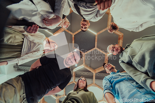 Image of A group of young businessmen offer their hands together, symbolizing togetherness in the business world