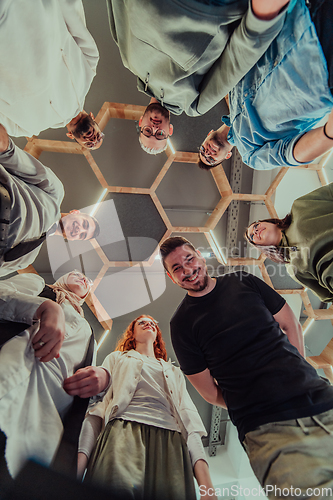 Image of A group of young businessmen offer their hands together, symbolizing togetherness in the business world