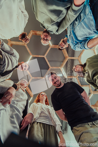 Image of A group of young businessmen offer their hands together, symbolizing togetherness in the business world