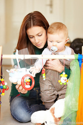 Image of Mother, baby and playing with toys in living room for childhood development in home. Woman, son and hold with pacifier for care, love and support in bonding, together and future growth with games