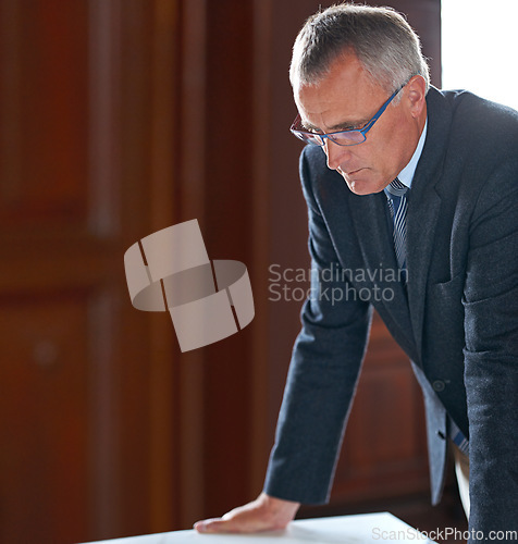 Image of Senior businessman, office or thinking of corporate idea, strategy or project planning for a solution. Thoughts, mature manager or serious CEO by table contemplating company finance, ideas or mission