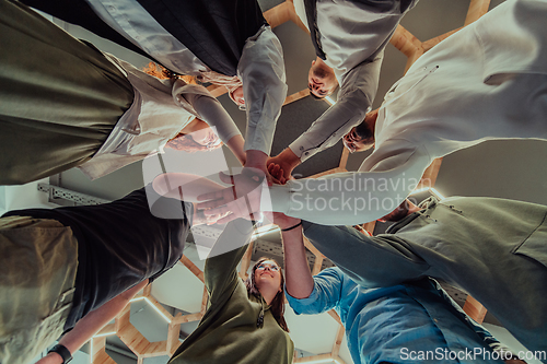 Image of A group of young businessmen offer their hands together, symbolizing togetherness in the business world