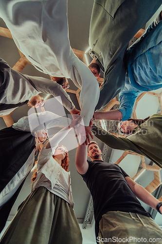 Image of A group of young businessmen offer their hands together, symbolizing togetherness in the business world