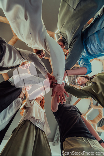 Image of A group of young businessmen offer their hands together, symbolizing togetherness in the business world