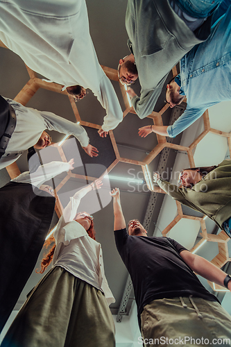 Image of A group of young businessmen offer their hands together, symbolizing togetherness in the business world