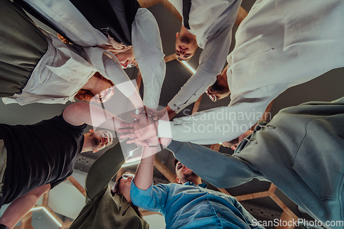 Image of A group of young businessmen offer their hands together, symbolizing togetherness in the business world