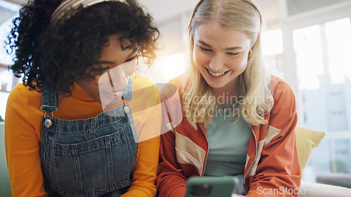 Image of Phone, friends and wow of women in home living room streaming on internet. Smartphone, happy girls and surprise on social media, video and interracial bonding on website together to smile on sofa.