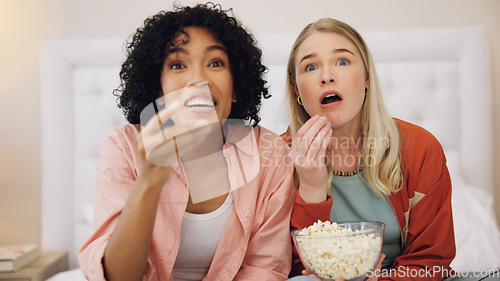 Image of Horror, television and women friends with popcorn on bed for scary, movie or serial killer documentary at home. Watching tv, face and ladies in bedroom with terror, film or video, snack and streaming