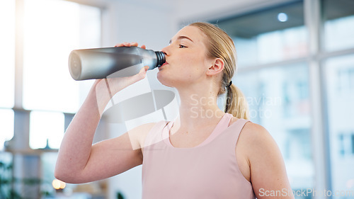 Image of Woman, home and drink of water for sports break, energy and workout performance. Thirsty athlete, bottle and nutrition of hydration, diet or healthy liquid for training, exercise or fitness in lounge