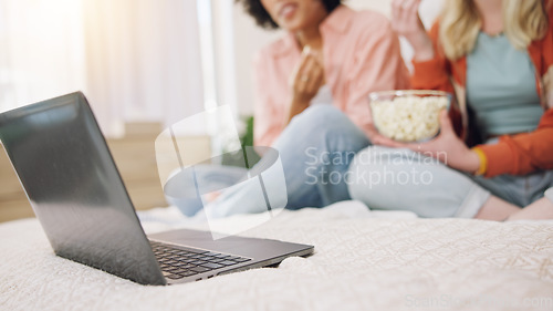 Image of Laptop, movie and women friends on a bed with popcorn for comedy, program or film in their home. Online, video and ladies in a bedroom with snack for streaming, comic or stand up, show or documentary