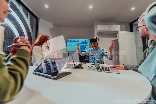 Image of A diverse group of businessmen collaborates and tests a new virtual reality technology, wearing virtual glasses, showcasing innovation and creativity in their futuristic workspace