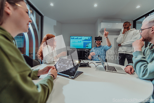 Image of A diverse group of businessmen collaborates and tests a new virtual reality technology, wearing virtual glasses, showcasing innovation and creativity in their futuristic workspace