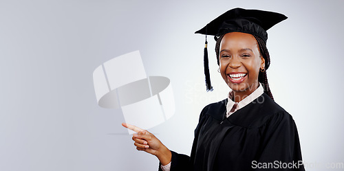 Image of Graduation student, woman pointing and space for education, learning or college presentation in studio. Portrait of african graduate with information, registration steps or banner on white background