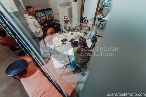 Image of A diverse group of businessmen collaborates and tests a new virtual reality technology, wearing virtual glasses, showcasing innovation and creativity in their futuristic workspace