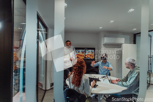 Image of A diverse group of businessmen collaborates and tests a new virtual reality technology, wearing virtual glasses, showcasing innovation and creativity in their futuristic workspace