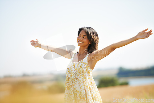 Image of Smile, freedom and woman with arms raised at field outdoor in the countryside in spring. Happy person in nature, eyes closed and relax in garden or farm, breathe fresh air to enjoy vacation or travel