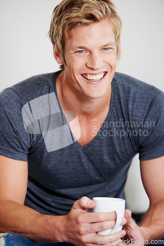 Image of Portrait, smile and coffee with a man in studio on a gray background to drink a caffeine beverage in the morning. Relax, break and mug with a happy young person drinking tea or feeling satisfied