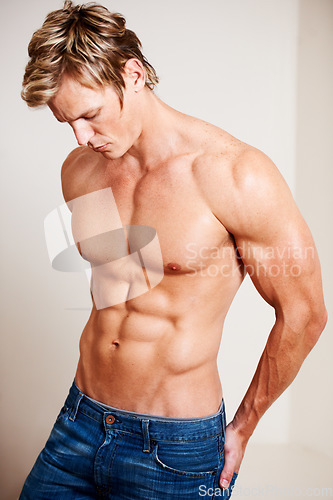 Image of Man, topless and muscle on studio background or fashion confidence, abs or chest. Male person, model or shirtless or denim jeans or masculine strength for flexing pose or attractive, strong in Norway