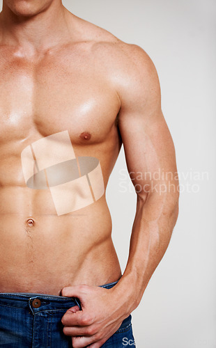 Image of Man, fitness and muscle with abs, sexy and shirtless for chest, strong and model in studio background. Alone, hot and jeans for six pack, topless and bodybuilder for health, exercise and pose