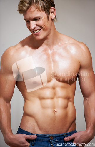 Image of Bodybuilder, man and six pack with sexy smile, topless and body with muscle, strong and model in studio background. Confident, workout and fitness with stomach, chest for health, exercise and abs