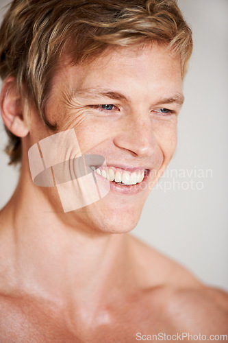 Image of Man, topless and smile in studio or white background for positive energy, healthy or confidence. Male person, model or shirtless relax masculine for strong shoulders or attractive, calm or muscle