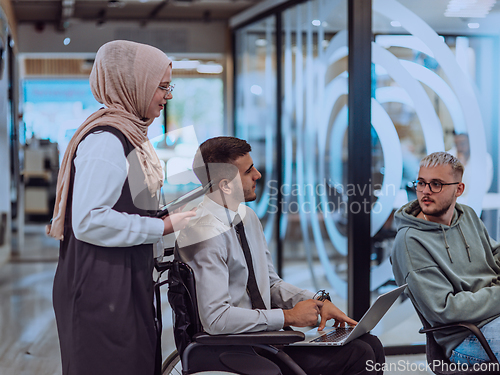 Image of Young group of business people brainstorming together in a startup space, discussing business projects, investments, and solving challenges.