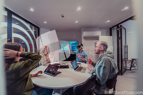 Image of A diverse group of businessmen collaborates and tests a new virtual reality technology, wearing virtual glasses, showcasing innovation and creativity in their futuristic workspace