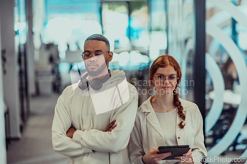 Image of In a modern office African American young businessman and his businesswoman colleague, with her striking orange hair, engage in collaborative problem-solving sessions