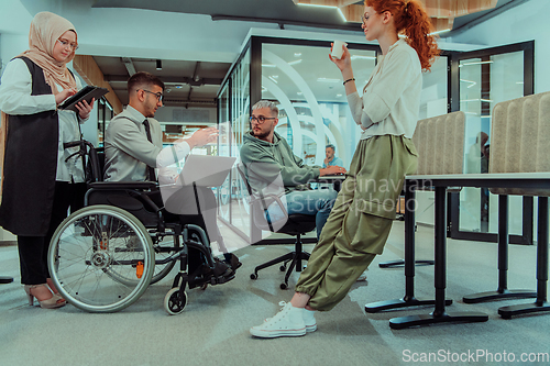 Image of Young group of business people brainstorming together in a startup space, discussing business projects, investments, and solving challenges.