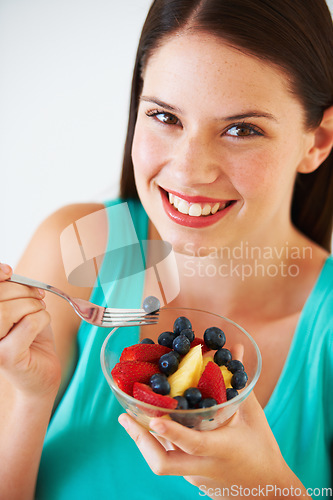 Image of Health, fruit salad and portrait of woman with berries eating for nutrition, wellness and snack in studio. Food, happy and face of person for vitamins, detox and lose weight on white background