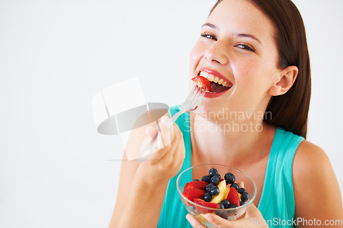 Image of Fruit salad, happy and portrait of woman in studio eating for nutrition, wellness and snack. Food, balance diet and face of person with berries for vitamins, detox and lose weight on white background