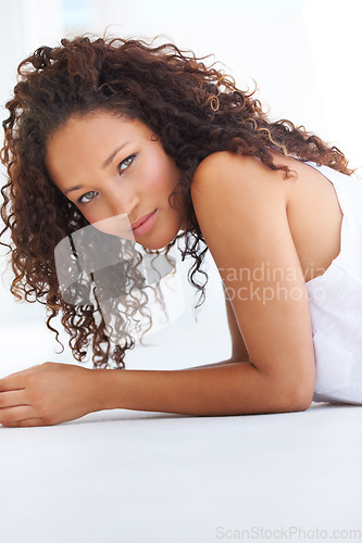 Image of Portrait, beauty or hair and a natural black woman on the floor with space on a white background to relax. Face, feminine and a confident young model on the ground for wellness or satisfaction